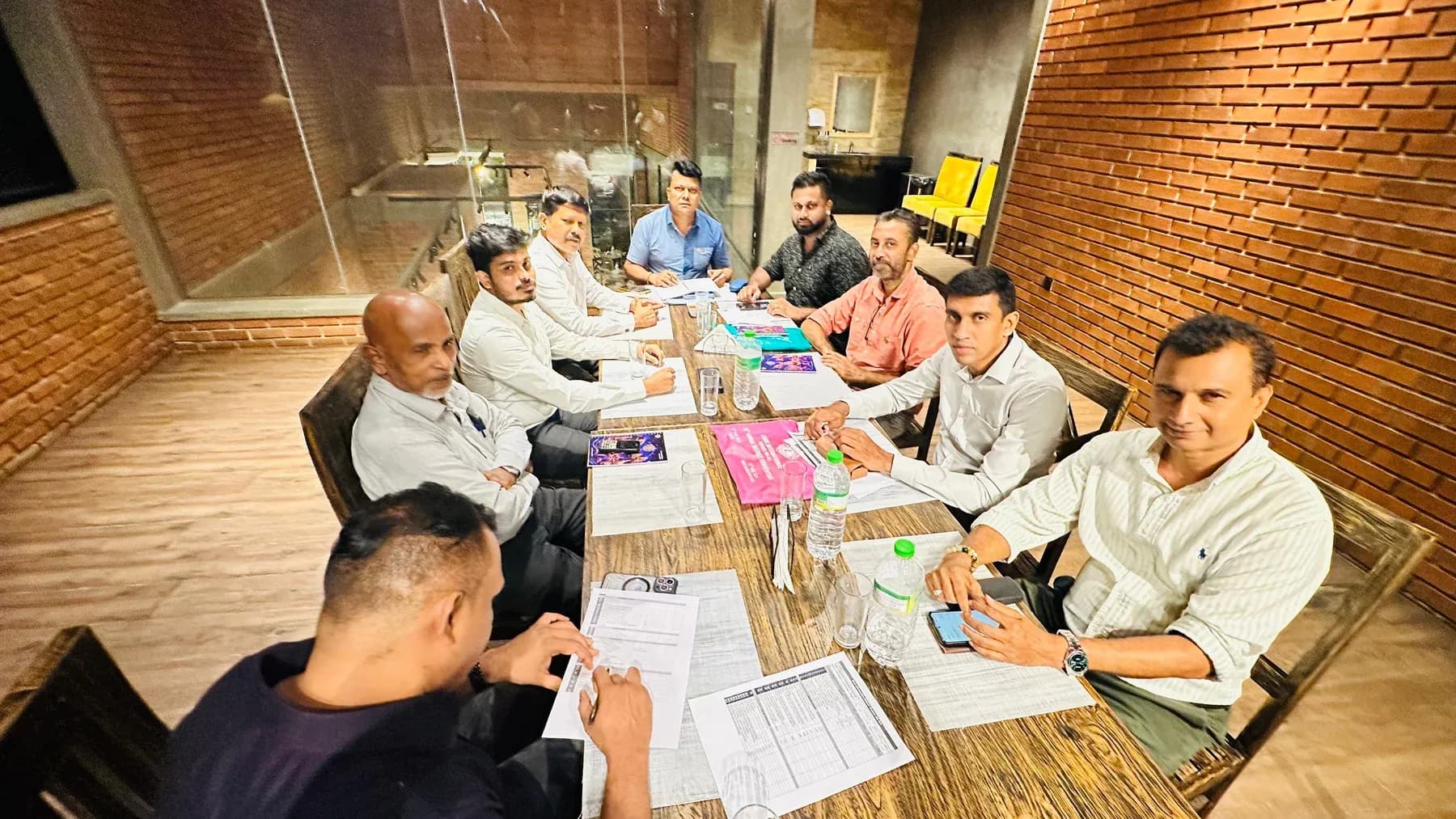 Club members meeting around a table with documents and notebooks.
